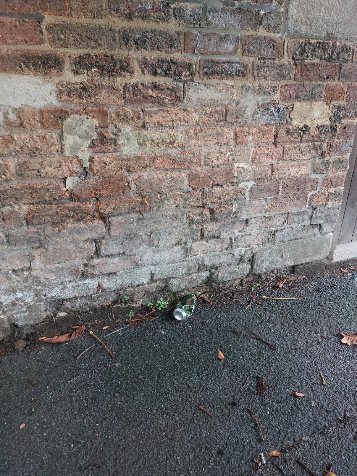 Weathered external brickwork with areas of deteriorated mortar and patch repairs